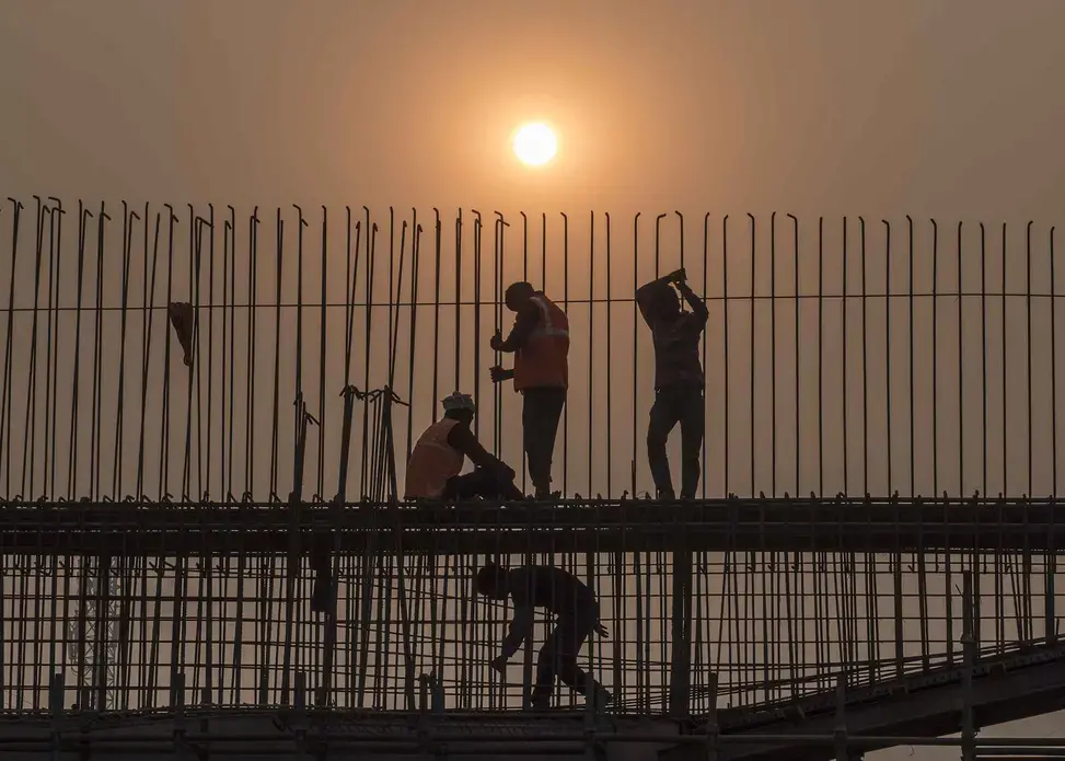 The rapid growth of the city far exceeds any effort to control associated pollution. Here, workers tie rebar at a bridge construction site in downtown Patna. Image by Larry C. Price. India, 2018.