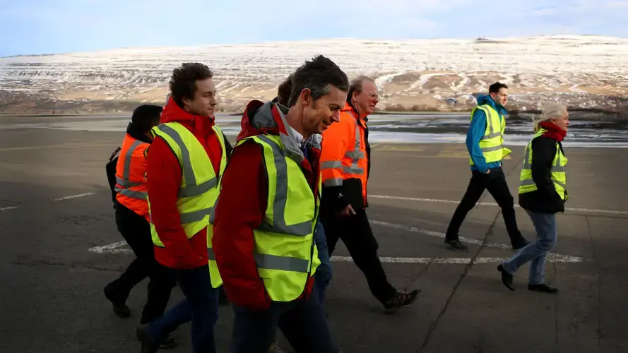 Ian Renfew, front center, and the atmospheric science team walk along the tarmac of the Akureyri airport. Image by Ari Daniel. Iceland, 2018.