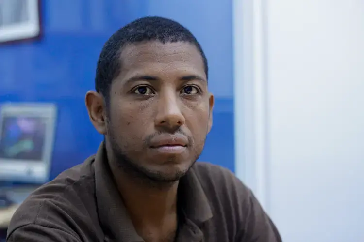 Carlos Román, a 37-year-old man with dark brown skin and black eyes poses for a photo portrait, wearing a brown shirt. He has been a dialysis patient for six years, after suffering kidney failure in 2012. He was registered in the national waiting list for organ donations, but with the stoppage of the organ procurement system in 2017, he now has no chance of getting a kidney for a transplant that could restore his health. 