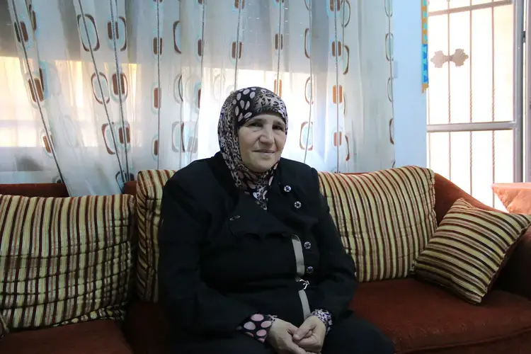 Hind Izzat sits in her small apartment, where she lives with over 100 Syrian refugees, all widows and orphans. Image by Sawsan Morrar. Jordan, 2017.
