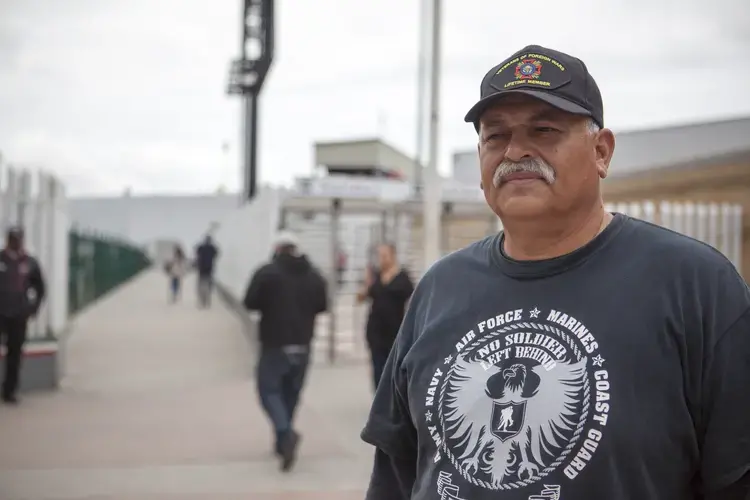Hector Lopez, director of the organization Unified U.S. Deported Veterans, stands outside the walkway where deportees arrive in Tijuana, Mexico. Tijuana, Mexico. May 2019. Image by Erin Siegal Mclntyre.