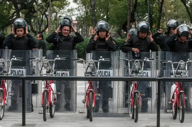 Riot police assemble behind a bikeshare station, in 2013, preparing to confront a march organized by teachers unions opposed to Peña Nieto’s educational reforms. Image by Eneas De Troya. Mexico, 2013.