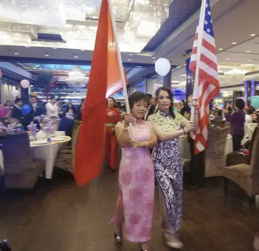 Former Tingjiang Secondary School students hold Chinese and American flags at an alumni association meeting in September. The association boasts more than 15,000 members in the United States. Image by Rong Xiaoqing. United States, 2016.</p>
<p>