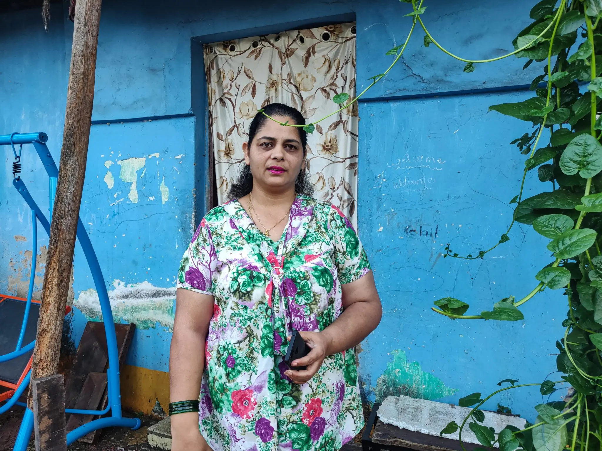 Woman stands in front of her home in Goa