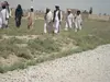 Men walk from a cemetery in Kampirak after a burial. Afghanistan, 2011.