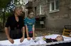 Dumitru Stupalov lies in a casket during a wake. His mother, Evgenia, and daughter, Maria, stand over him.