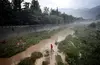 A man walks through one of the drainage channels that make up the Dujiangyan Irrigation system. China. Sean Gallagher, 2010