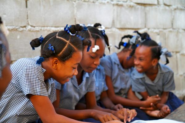 Cynthia and her friends in the school yard at L'Ecole Republique du Chili in Port au Prince. Image by Jon Sawyer. Haiti, 2012.