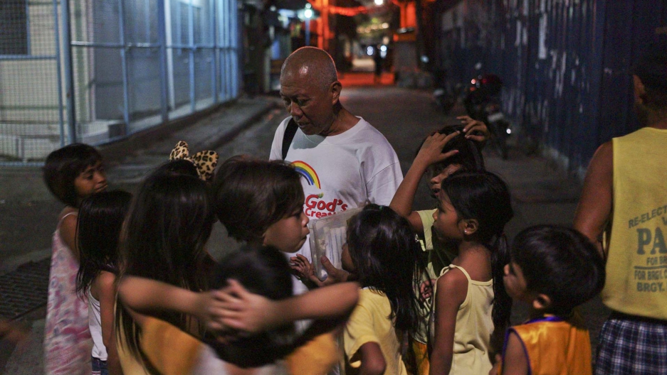 Brother Paul heads out at night with baggies filled with biscuits for kids, and medicines for adults with HIV. He also distributes clean needles and condoms to those in need. Image by Veejay Villafranca. Philippines, 2015. Media file: cropbrotherpaul.jpg