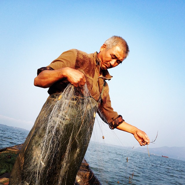 Cao Suizhou, a Chinese fisherman on the Danjiangkou reservoir, is used to moving. He's been forcibly relocated three times for China's country’s colossal water projects and each time he's rebuilt his life from scratch. In 2009 Cao’s village was moved to make way for China's South-to-North Water Transfer Project, his small business was torn down along with his home. While Cao's wife relocated to the new village, Cao moved onto his boat to sustain the family’s livelihood. Image by Sharon Lovell. China, 2015. Media file: caosuizhou.jpg