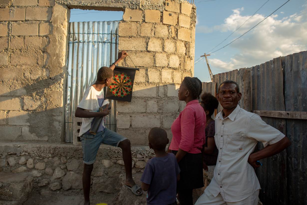 Alisma Robert, right, and children Esaie Robert, 15, Roberson Robert, 7, and Kerline Reobert, 18, standing, enjoy the evening at their home in the Canaan 3 neighborhood of greater Canaan, Haiti, January 7. Thomson Reuters Foundation. Image by Allison Shelley. Haiti, 2019. Alisma Robert, right, and children Esaie Robert, 15, Roberson Robert, 7, and Kerline Reobert, 18, standing, enjoy the evening at their home in the Canaan 3 neighborhood of greater Canaan, Haiti, January 7. Thomson Reuters Foundation. Image by Allison Shelley. Haiti, 2019.