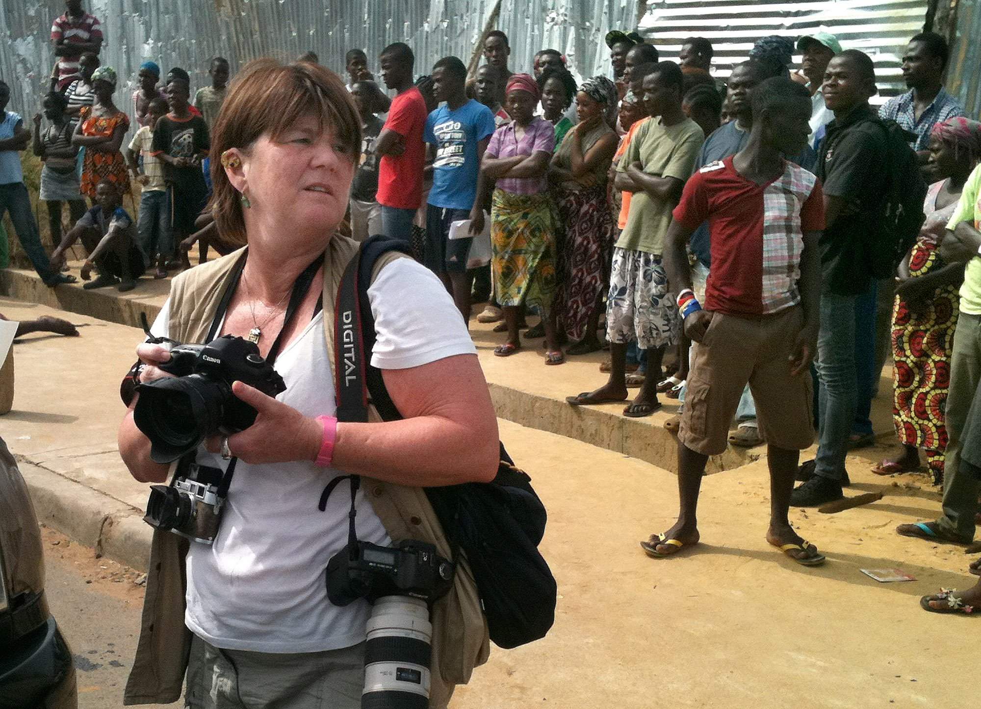 Cheryl Hatch documents the scene of a crime on 72nd Street in Monrovia, Liberia, on Friday, Jan. 9, 2015. Hatch is a photojournalist and visiting professor of journalism in the public interest at Allegheny College. She is in Liberia covering the U.S. military's efforts to help the Liberian government combat Ebola. She is traveling with writer Brian Castner, author of "The Long Walk." Image by Brian Castner. Liberia, 2014.