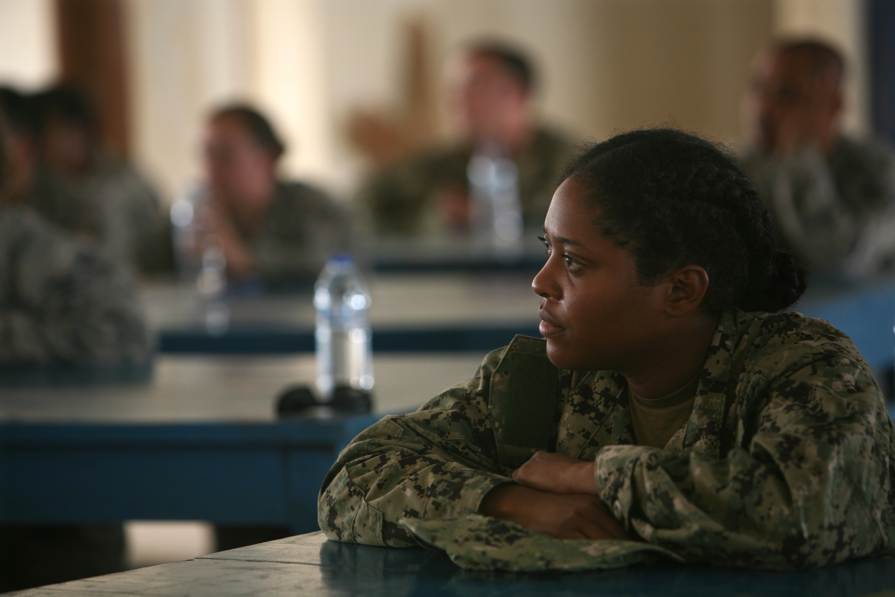 Hospital Corpsman Third Class Julia Hollingsworth listens to a lecture with her fellow trainers from the U.S. Navy, Air Force and Army at the National Police Training Center in central Monrovia. Hollingsworth went to Liberia in the middle of a healthcare crisis, to teach foreign hospital workers how to survive Ebola. Image by Cheryl Hatch. Liberia, 2014. Media file: hollingsworth_7552.jpg