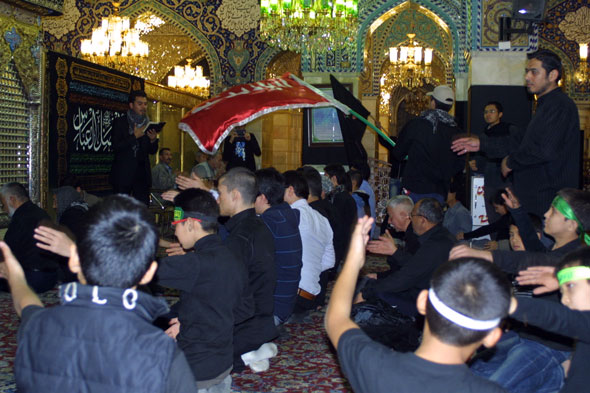 Young men attend a ceremony at the Rukaya Shrine in Damascus. Shiites and Alawites, seen here, tend to support the Assad government. Image by Reese Erlich. Syria, 2013. Media file: rukaya-shrine-1-590.jpg