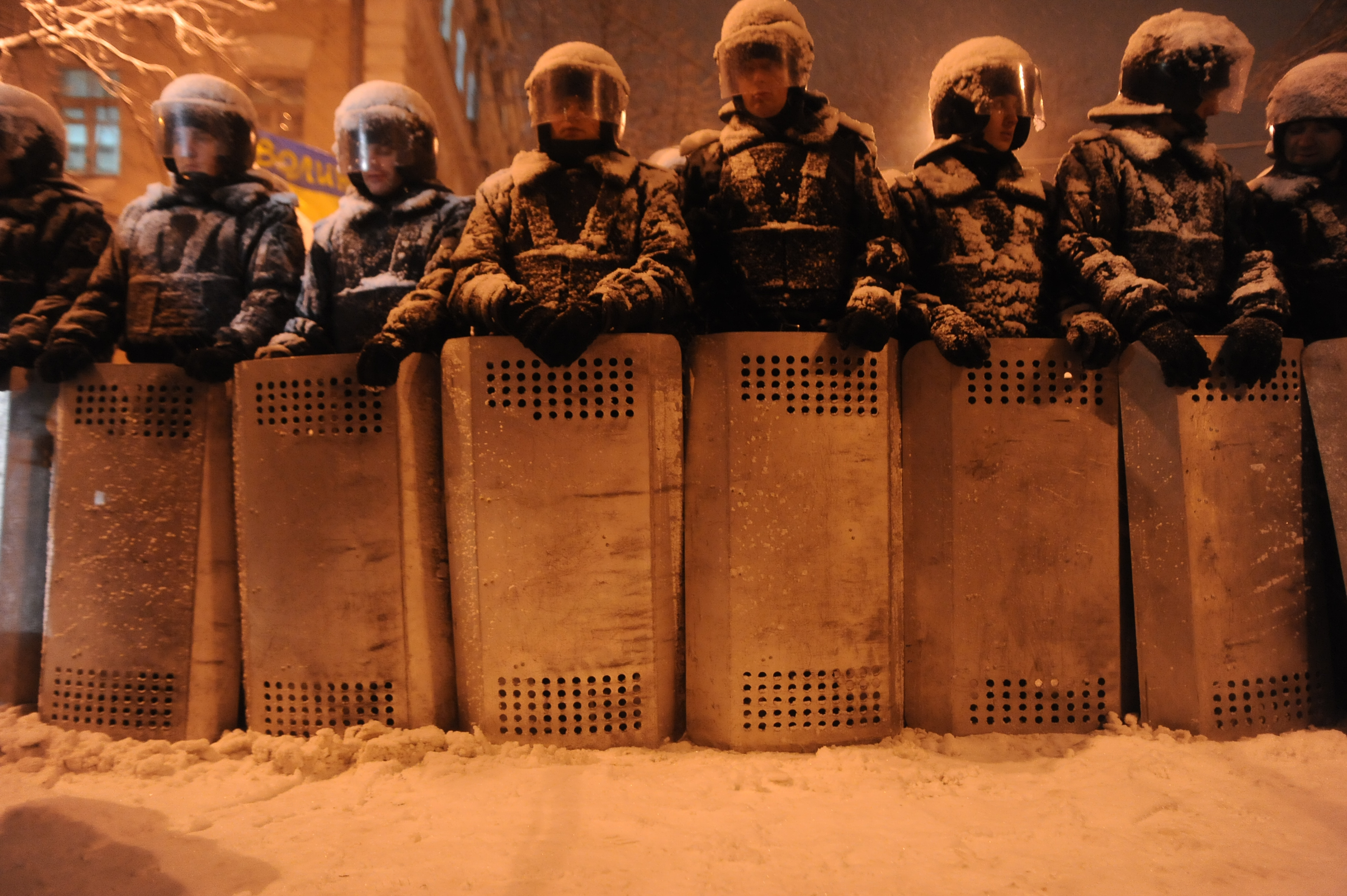 A line of riot police officers under the heavy snow fall in Kiev. Image by Mstyslav Chernov/Unframe. Courtesy of Wikicommons. Ukraine, 2013.