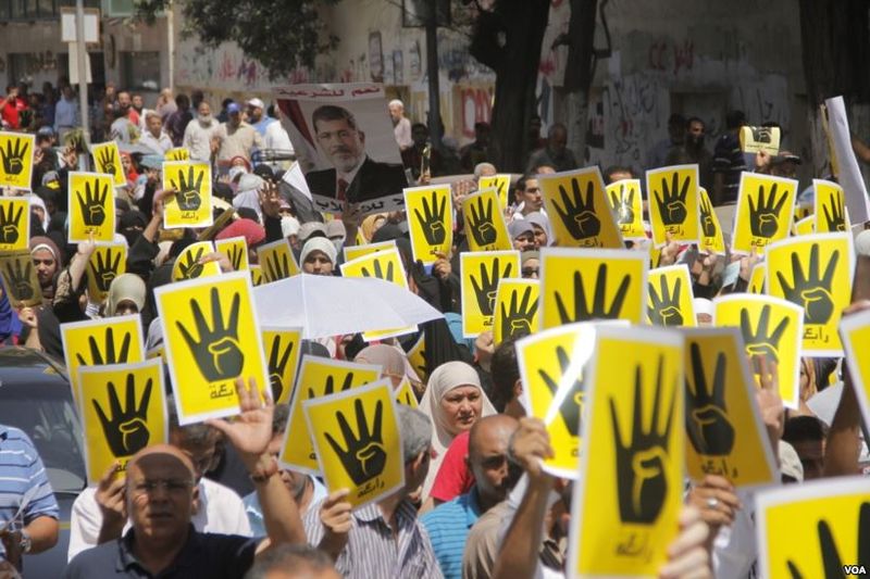 Demonstrators hold up four fingers, a symbol of their solidarity with the the destroyed sit-in protest known as Rabaa, which means four or fourth in Arabic, Cairo, August 23, 2013. Image by H. Elrasam for VOA. Courtesy of Wikimedia Commons. Egypt, 2013.