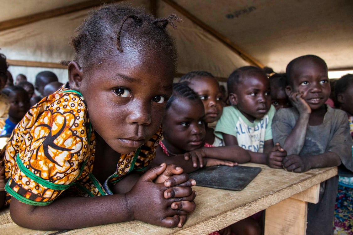 Children are taught in a makeshift classroom at a camp in Kaga Bandoro that provides refuge for thousands of Central African families displaced by conflict. Image by Jack Losh. Central African Republic, 2019. Children are taught in a makeshift classroom at a camp in Kaga Bandoro that provides refuge for thousands of Central African families displaced by conflict. Image by Jack Losh. Central African Republic, 2019.