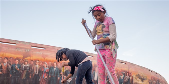 An 8-year-old child, right, and her friend sweep the pavement outside the Jaime Laredo Outdoor Theater in La Paz. Children are allowed to work for themselves or their families at age 10 in Bolivia. At 12, they can work for others. Image by Tracey Eaton. Bolivia, 2018. An 8-year-old child, right, and her friend sweep the pavement outside the Jaime Laredo Outdoor Theater in La Paz. Children are allowed to work for themselves or their families at age 10 in Bolivia. At 12, they can work for others. Image by Tracey Eaton. Bolivia, 2018.