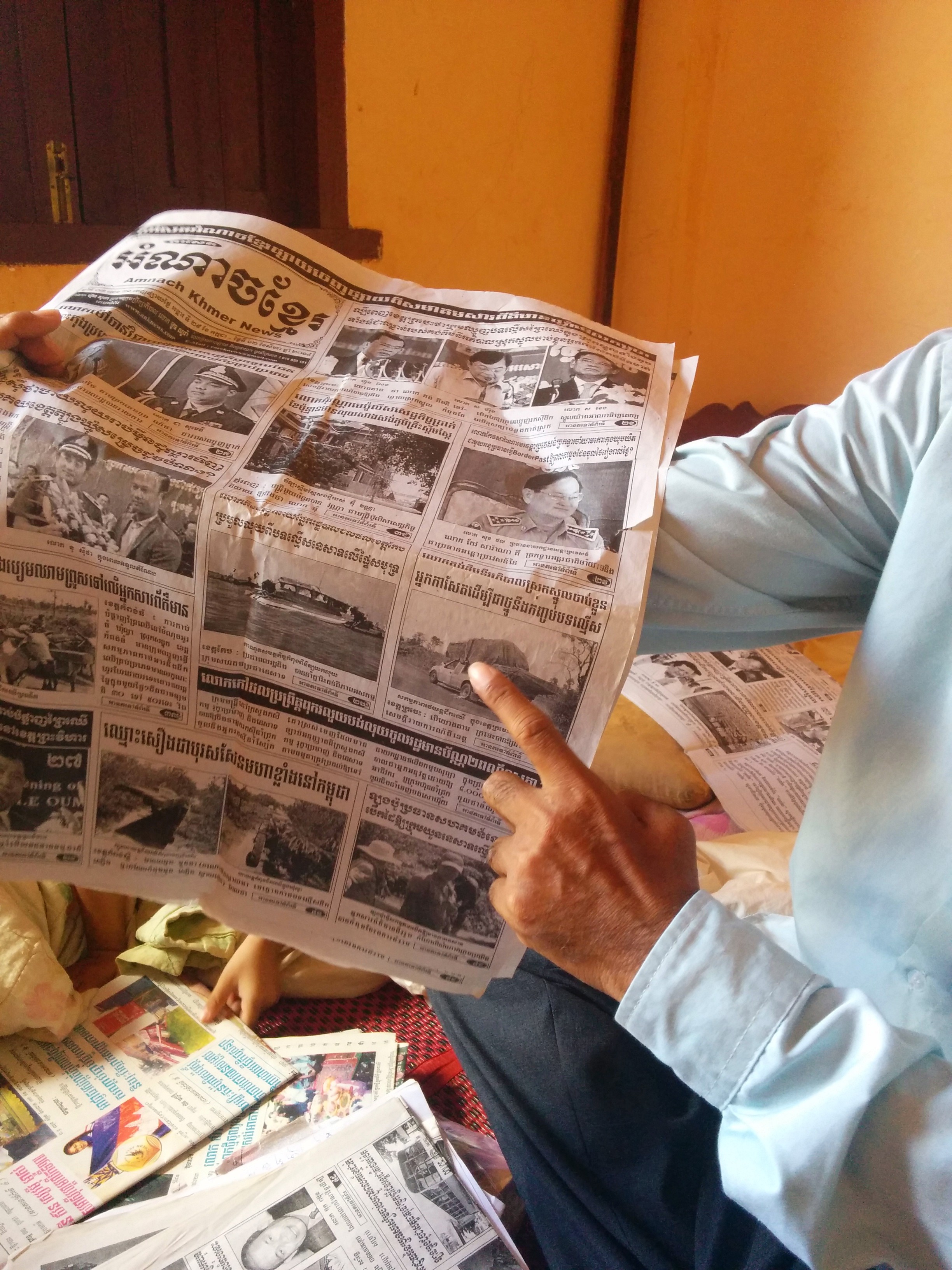 Journalist Sa Piseth shows one of his articles on illegal logging in the Reaksmey Kom Khmer newspaper. Image by Saul Elbein. Cambodia, 2014. Journalist Sa Piseth shows one of his articles on illegal logging in the Reaksmey Kom Khmer newspaper