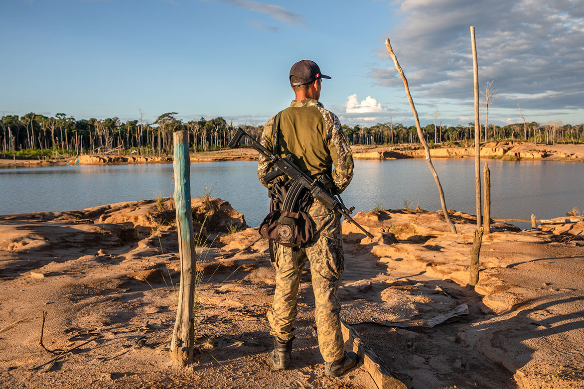 A soldier patrols La Pampa, an area in Peru that was once lush rainforest. Image by Brett Gundlock. Peru, 2019. A soldier patrols La Pampa, an area in Peru that was once lush rainforest. Image by Brett Gundlock. Peru, 2019.