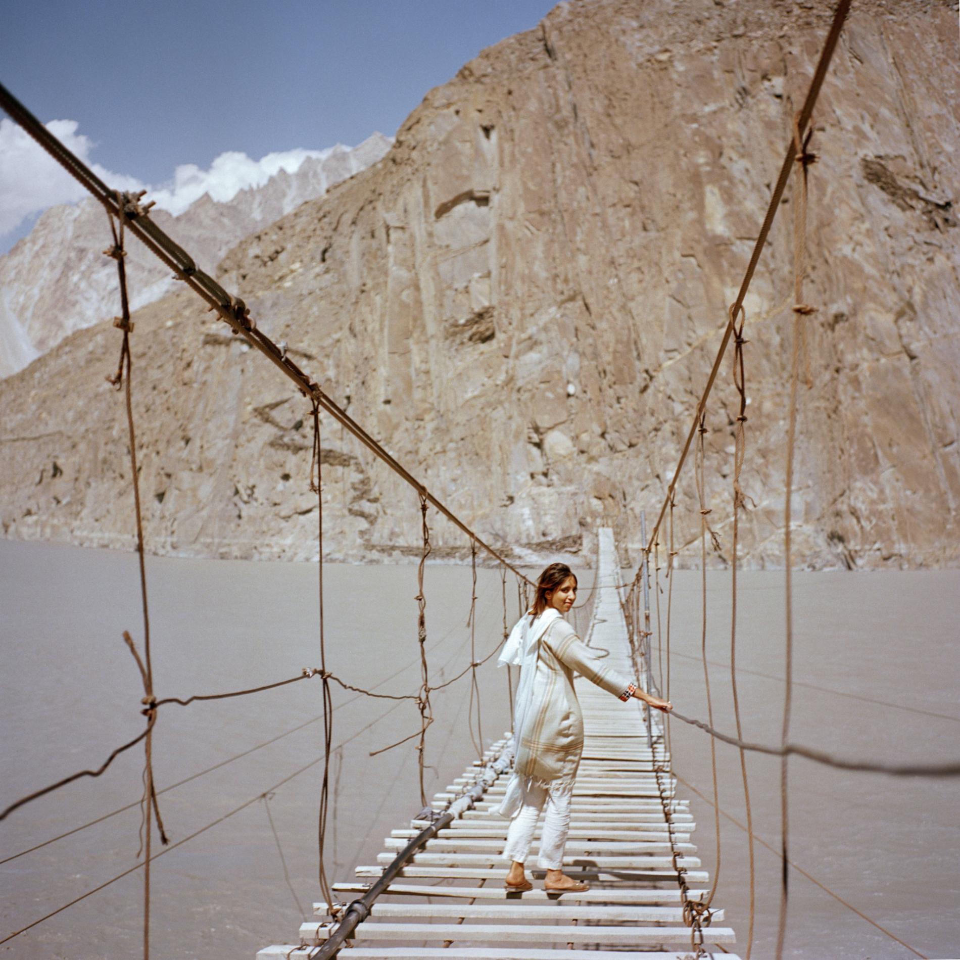British visitor Subeera Hussain walks along a hanging bridge near Passu, a town in the Hunza valley of northern Pakistan. She wishes more people knew about the country’s beauty. “Tell people about Pakistan, the real Pakistan” she says. “I’m traveling alone as a woman and I’ve never felt more safe.” Image by Sara Hylton/National Geographic. Pakistan, 2019. British visitor Subeera Hussain walks along a hanging bridge near Passu, a town in the Hunza valley of northern Pakistan. She wishes more people knew about the country’s beauty. “Tell people about Pakistan, the real Pakistan” she says. “I’m traveling alone as a woman and I’ve never felt more safe.” Image by Sara Hylton/National Geographic. Pakistan, 2019.