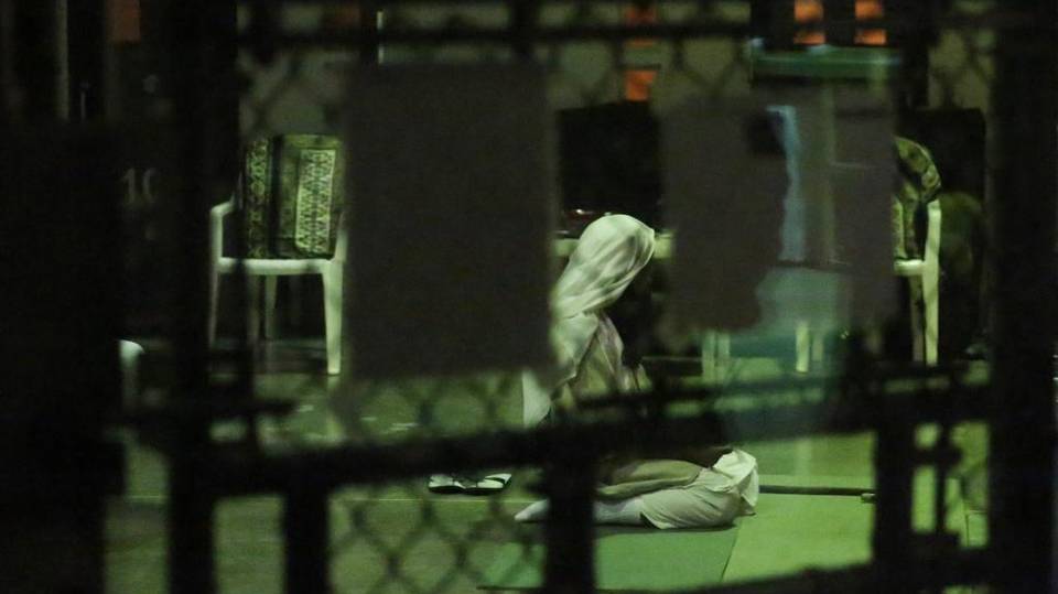 A detainee kneels in prayer at sunset on February 11, 2017, at Camp Six at Guantánamo’s Detention Center Zone. The military approved release of this photo. Image courtesy of Emily Michot/McClatchy. Cuba, 2019. A detainee kneels in prayer at sunset on February 11, 2017, at Camp Six at Guantánamo’s Detention Center Zone. The military approved release of this photo. Image courtesy of Emily Michot/McClatchy. Cuba, 2019.