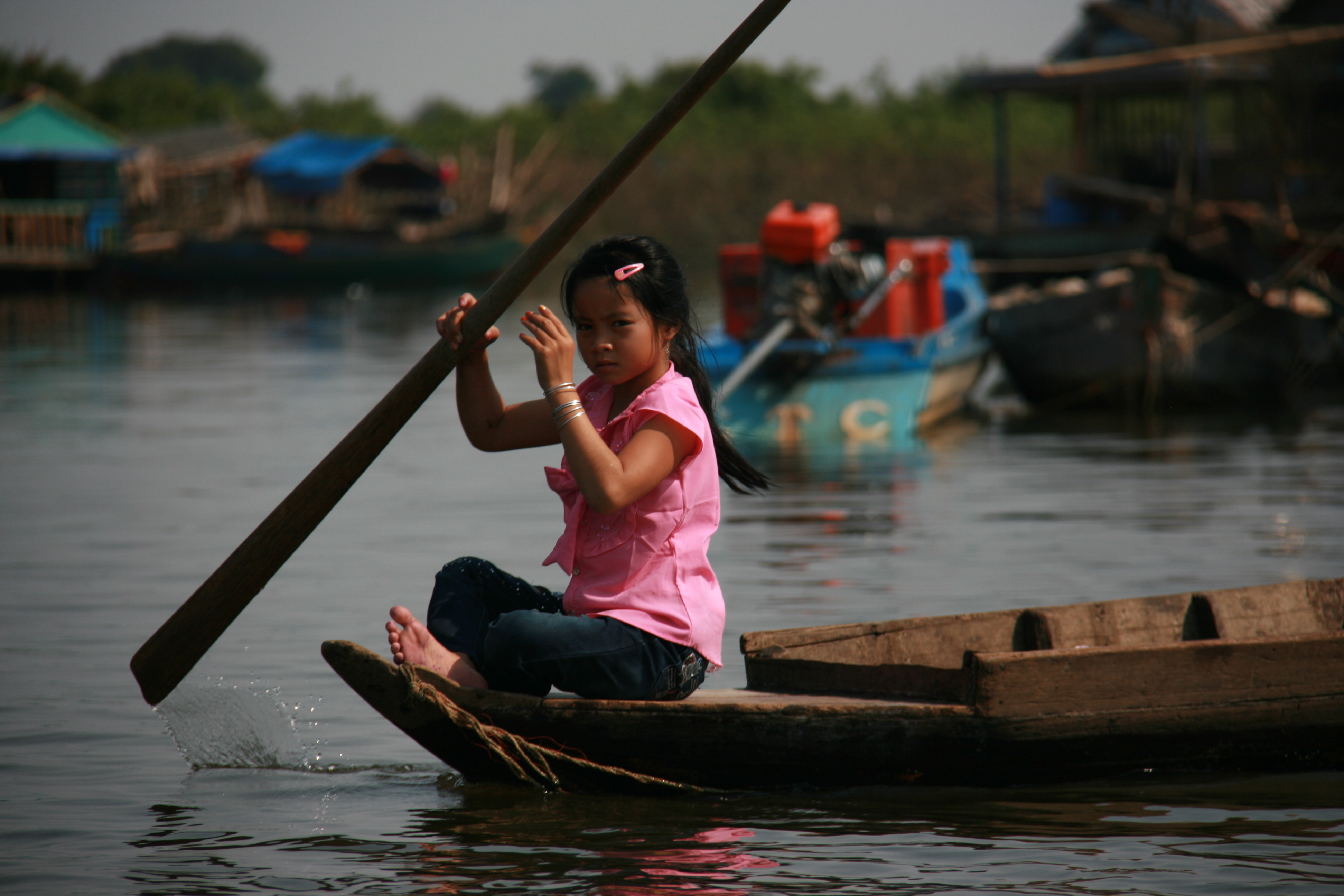 A girl paddles her way through a floating village on Lake Tonle Sap. Image by Chris Berdik. Cambodia, 2014. Media file: img_9428.jpg