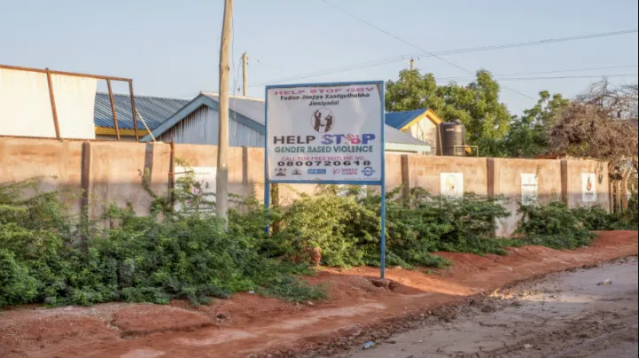 A sign advertising a hotline for people to call and report gender based violence related crimes in Wajir, Kenya. Image by Peter DiCampo. 2018. A sign advertising a hotline for people to call and report gender based violence related crimes in Wajir, Kenya. Image by Peter DiCampo. 2018.
