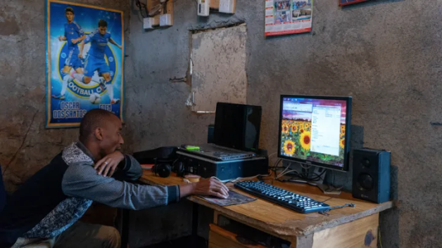 Caleb Yongo, a resident of the Gatwekera neighborhood in Kibera, Nairobi. Caleb runs a business from his house doing printing, photocopying, and typing. He uses an illegal power connection as that is the only power available for him. Image by Peter DiCampo. Kenya, 2018. Caleb Yongo, a resident of the Gatwekera neighborhood in Kibera, Nairobi. Caleb runs a business from his house doing printing, photocopying, and typing. He uses an illegal power connection as that is the only power available for him. Image by Peter DiCampo. Kenya, 2018.