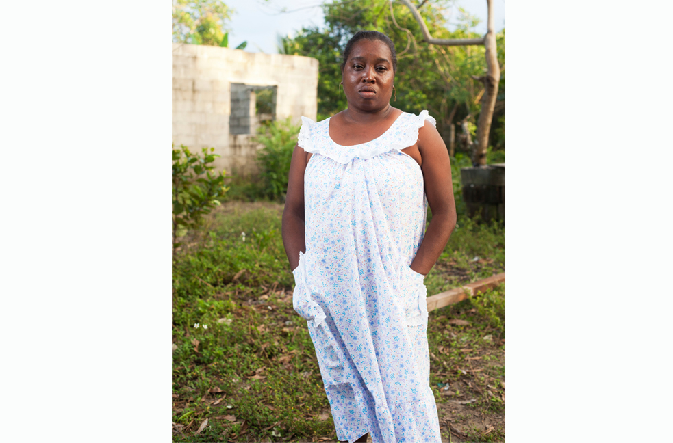 Ana Vilma Batiz stands outside of her home in Triunfo de la Cruz, Honduras. Image by David Rochkind. Honduras, 2013. Media file: ana.jpg