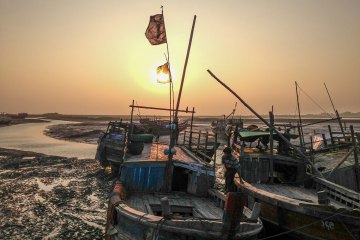 An ethnic Rohingya man climbs aboard his boat in Sittwe, Burma on Jan. 31, 2013. Image by Jason Motlagh. Burma, 2013.