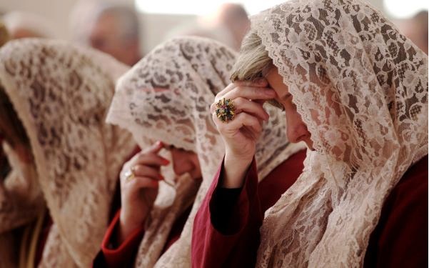 Syrian and Iraqi Christian families in Jordan praying for peace in their home countries. Image courtesy of Mohammad Hannon/AP. Jordan, 2014.