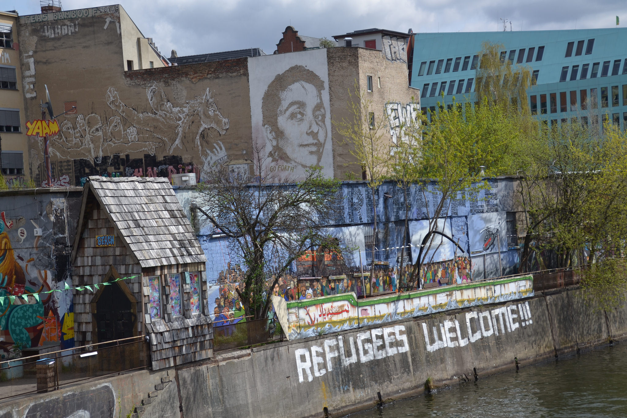 A mural in Berlin says "Refugees Welcome." Image by Jeanne Menjoulet. Berlin, 2016. A mural in Berlin says "Refugees Welcome." Image by Jeanne Menjoulet. Berlin, 2016.