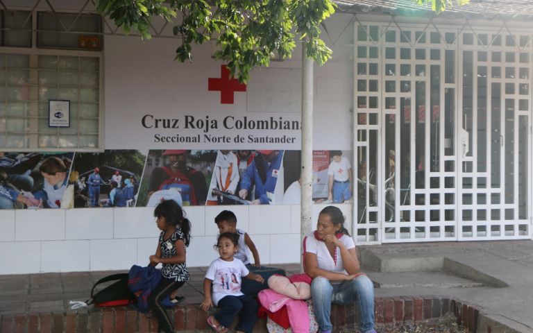 A Venezuelan family waits outside a Red Cross center in Norte de Santander. Image by Patrick Ammerman. Colombia, 2019. A Venezuelan family waits outside a Red Cross center in Norte de Santander. Image by Patrick Ammerman. Colombia, 2019.