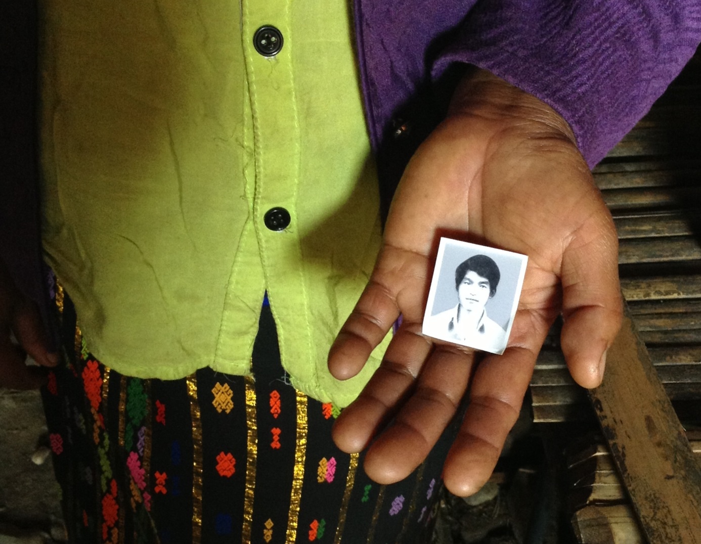 The wife of Lahpai Gam, an ethnic Kachin man arrested and allegedly tortured by Burmese security forces, holds the only known photograph of her husband. Image by Jason Motlagh. Burma, 2013. Media file: image.jpg