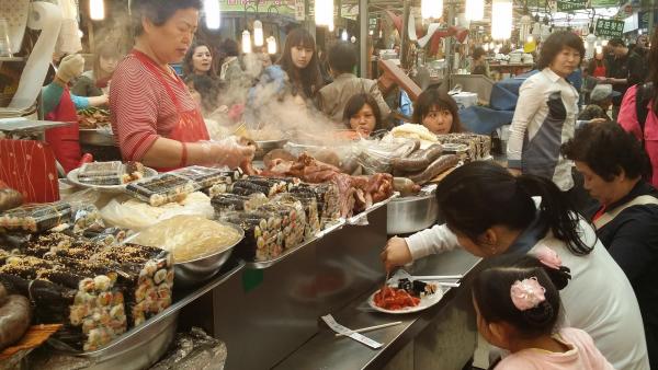 A food vendor sells local fare at one of the dozens of eateries inside the Gwangjang Market. Image by Karim Chrobog. South Korea, 2014.