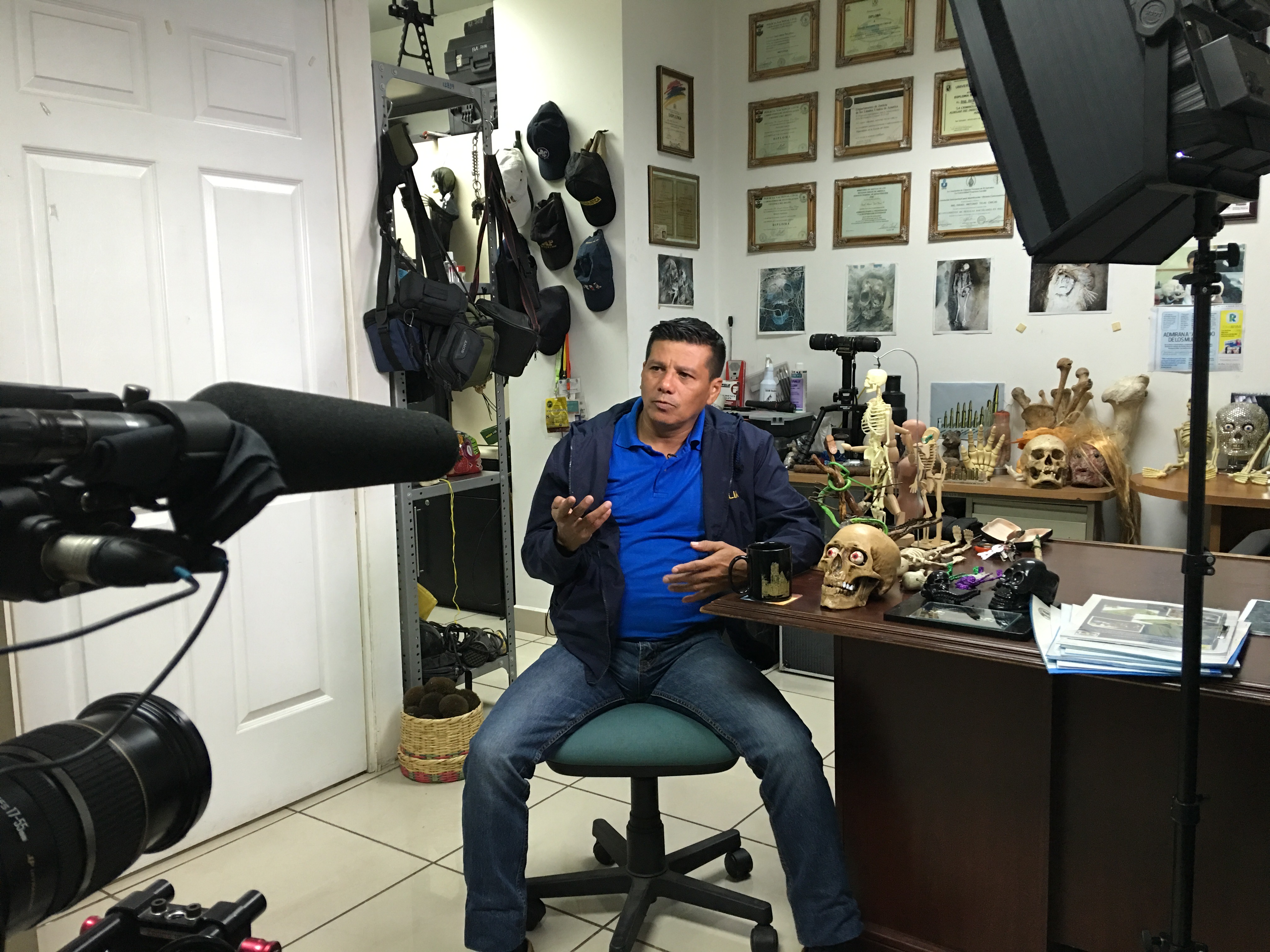 Forensic criminologist Israel Ticas speaks to media in the San Salvador office where he keeps grisly mementos from the crime scenes he has worked. Image by Jason Motlagh. Forensic criminologist Israel Ticas speaks to media in the San Salvador office where he keeps grisly mementos from the crime scenes he has worked. Image by Jason Motlagh.