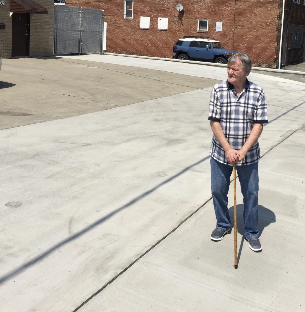 Elliot Feltner stands on the sidewalk in front of the auto body shop that was in his family for decades. Image courtesy of Eye on Ohio. United States, 2020. Elliot Feltner stands on the sidewalk in front of the auto body shop that was in his family for decades. Image courtesy of Eye on Ohio. United States, 2020.