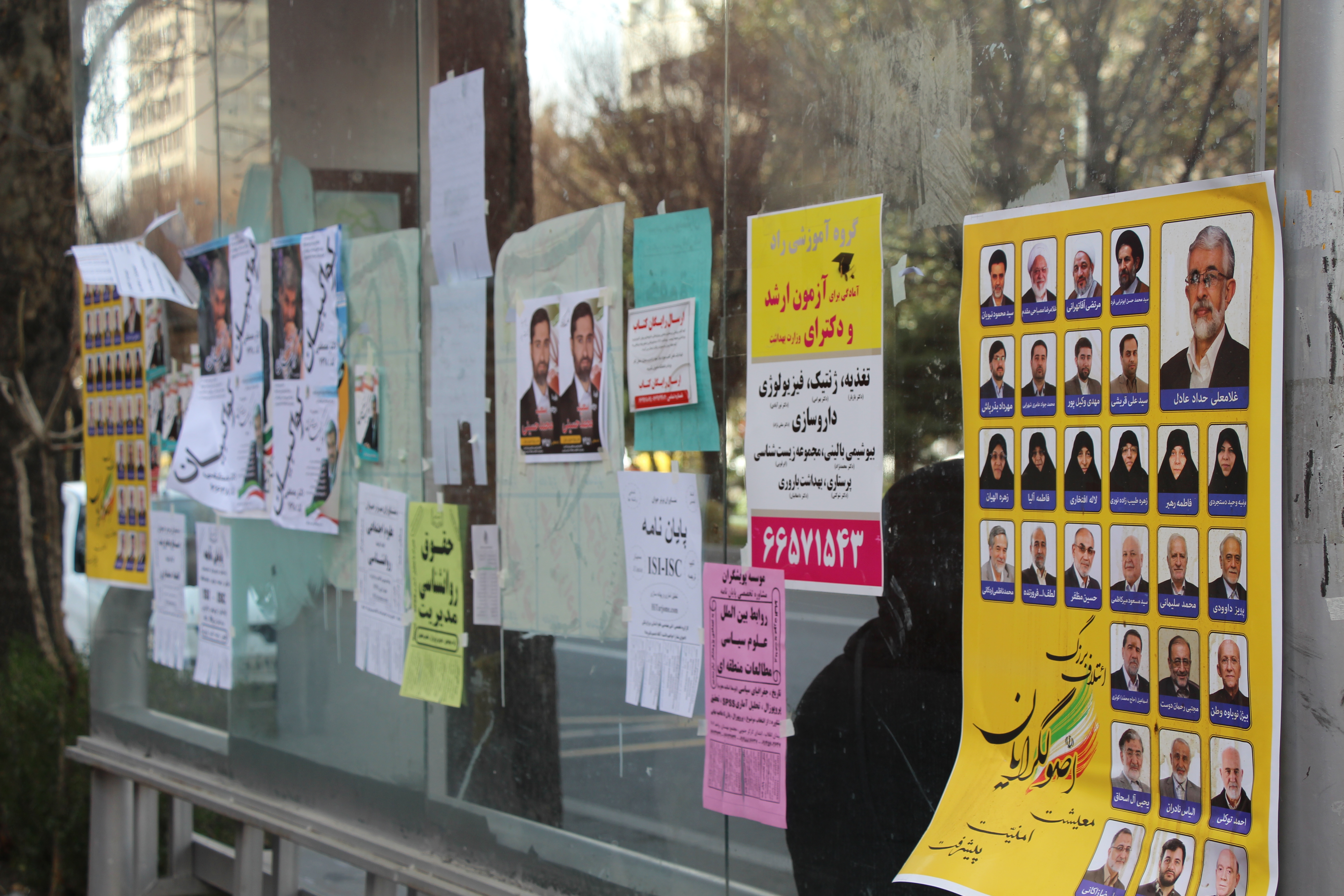 Image by Reese Erlich. Iran, 2016. Media file: bus_stop_posters.jpg