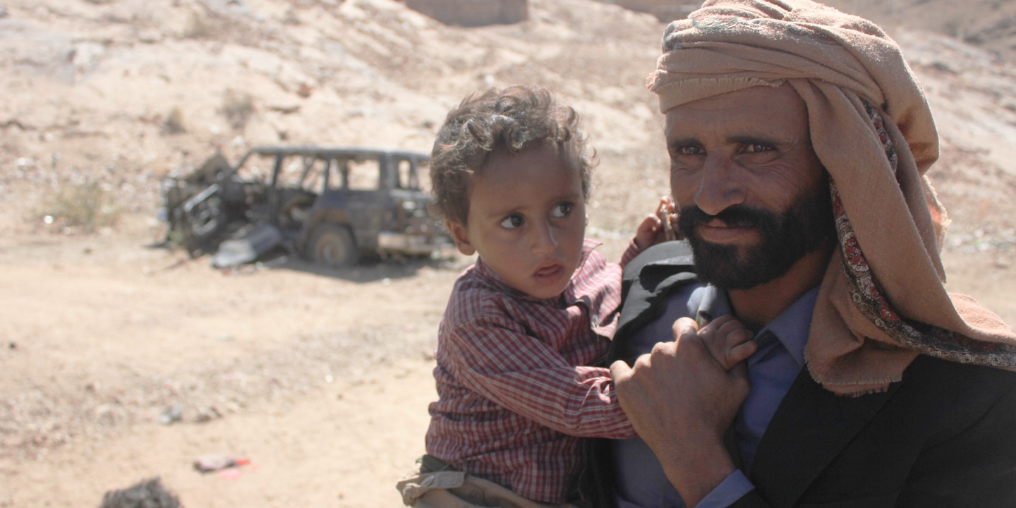 Mabkhout Ali al Ameri stands with his 18-month-old son, Mohammed, in the village of al Ghayil in Yemen’s al Bayda province. Mabkhout’s wife, Fatim Saleh Mohsen, was shot in the back of the head by helicopter gunship fire as she fled with Mohammed in her arms during a U.S. raid. Image courtesy of The Intercept. Yemen, 2017. Mabkhout Ali al Ameri stands with his 18-month-old son, Mohammed, in the village of al Ghayil in Yemen’s al Bayda province. Mabkhout’s wife, Fatim Saleh Mohsen, was shot in the back of the head by helicopter gunship fire as she fled with Mohammed in her arms during a U.S. raid. Image courtesy of The Intercept. Yemen, 2017.