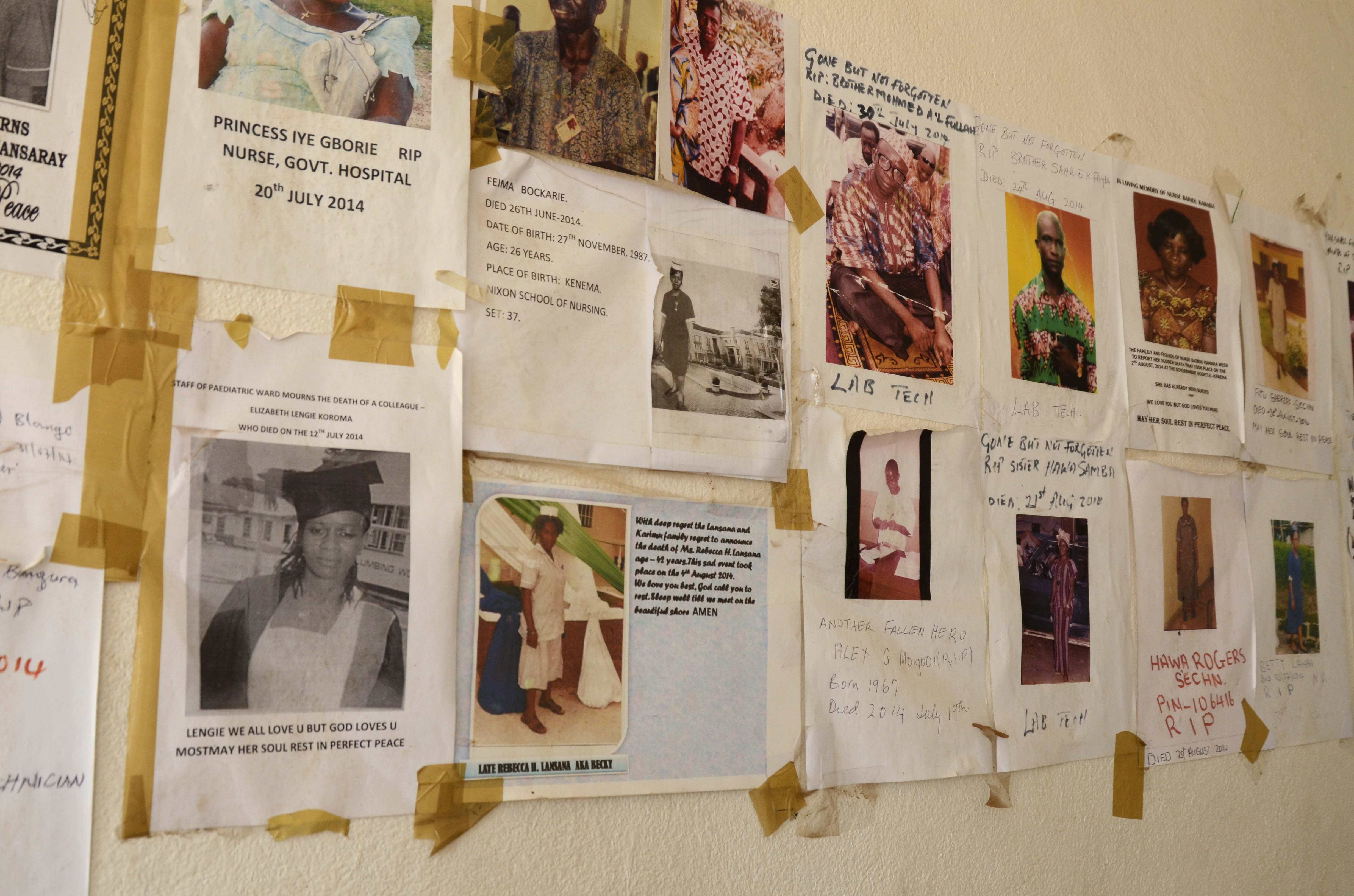 Fliers on hospital walls commemorate health workers who have died from Ebola in Sierra Leone. Researchers now want to test experimental Ebola vaccines on health workers, in order to learn whether the shots can prevent tragedy from occurring again. Image by Amy Maxmen. Sierra Leone, 2014.