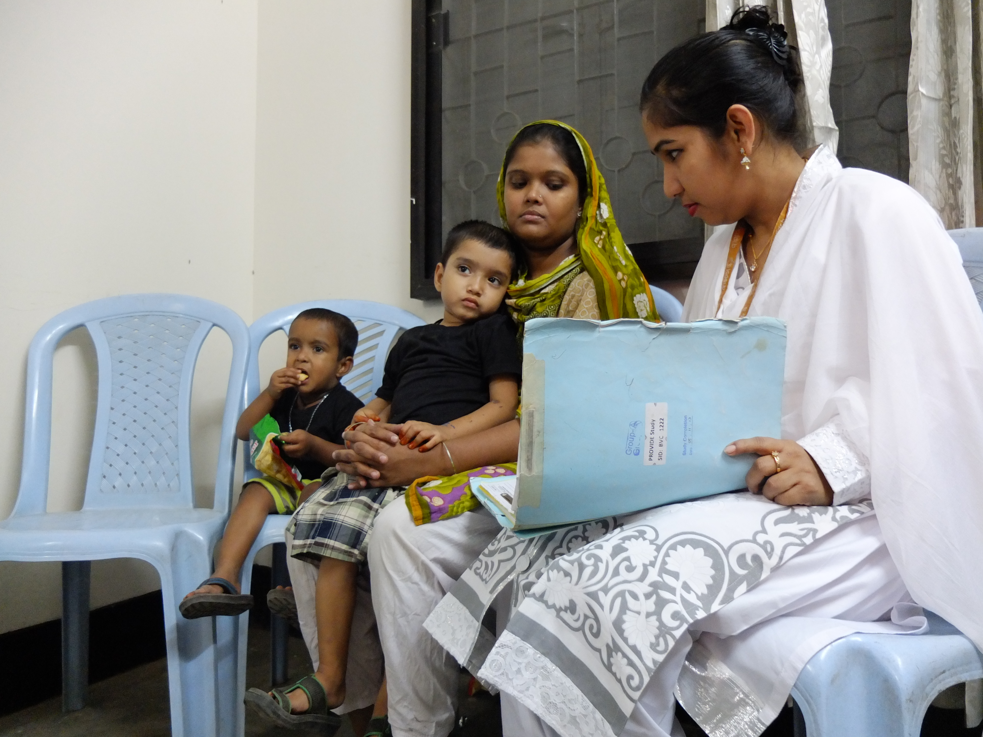 Mohommad Mustakim and his mother talk with researchers as part of a study of the rotavirus vaccine in Dhaka, Bangladesh. Mohommad got sick with rotavirus diarrhea even after getting the vaccine. Image by Carina Storr. Bangladesh, 2016.