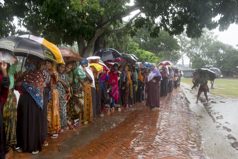 Women wait in line in the rain to collect 20kg bags of rice that is given out by the government as part of a VGF (Vulnerable Group Feeding) program ahead of Eid-ul-fitr in a southwestern village of the country. Image by Nikita Sampath. Bangladesh, 2016. Women wait in line in the rain to collect 20kg bags of rice that is given out by the government as part of a VGF (Vulnerable Group Feeding) program ahead of Eid-ul-fitr in a southwestern village of the country. Image by Nikita Sampath. Bangladesh, 2016.