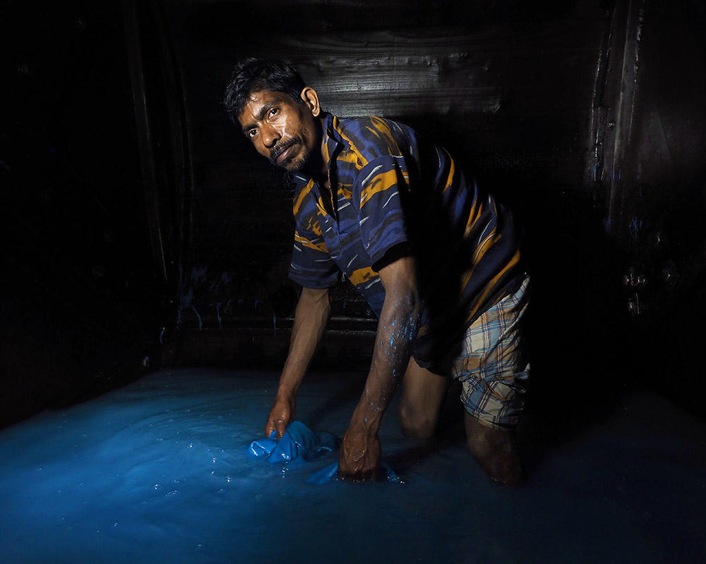 A barefoot worker stands inside an 8-foot tall-tumbling drum filled with chromium (III) sulfate and other chemicals. Workers often have to crawl inside the drums to remove hides. Image by Larry C. Price. Bangladesh, 2016. A barefoot worker stands inside an 8-foot tall-tumbling drum filled with chromium (III) sulfate and other chemicals. Workers often have to crawl inside the drums to remove hides. Image by Larry C. Price. Bangladesh, 2016.
