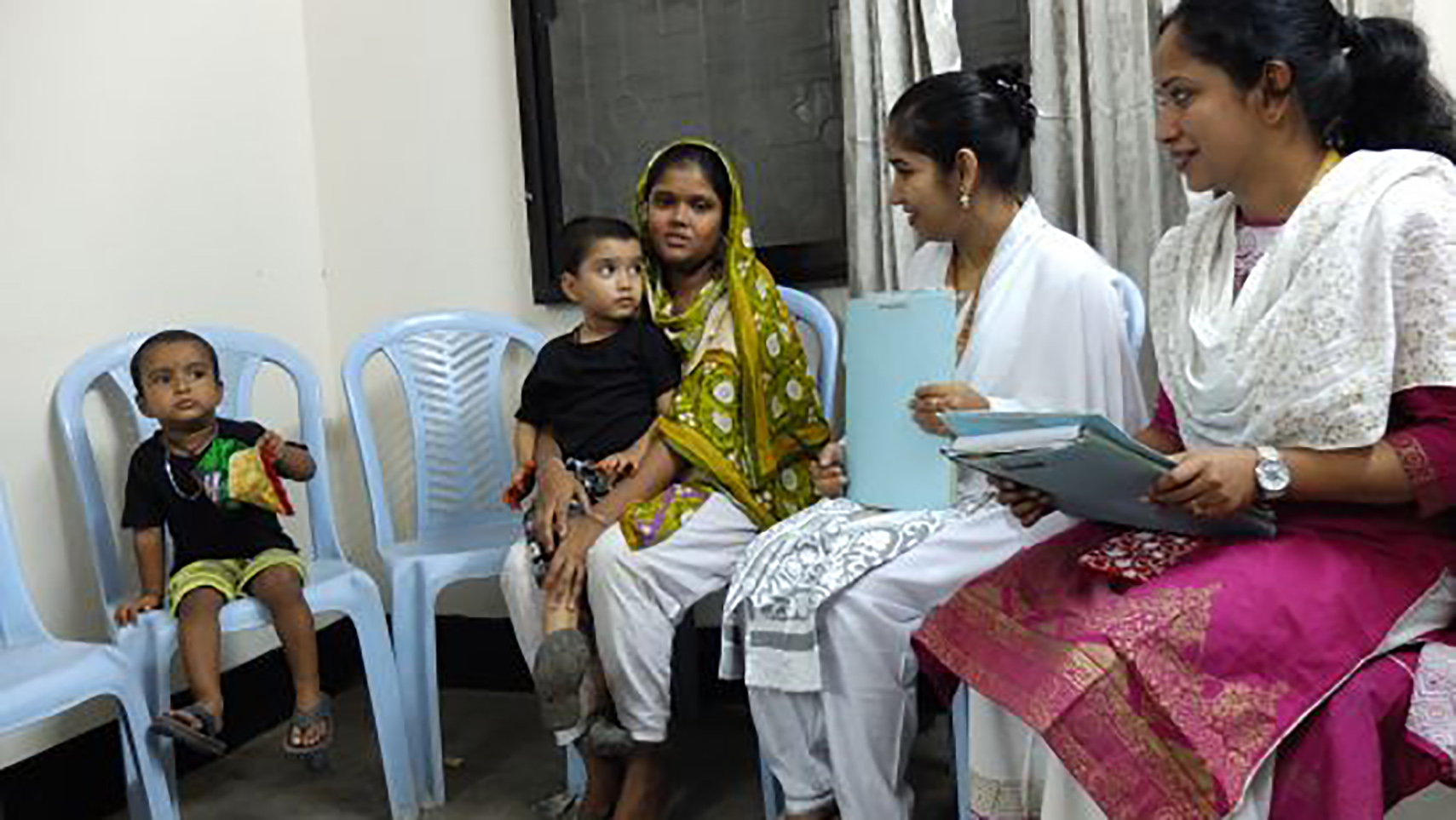 Mohommad Mustakim and his mother talk with researchers as part of a study of the rotavirus vaccine in Dhaka, Bangladesh. Mohommad got sick with rotavirus diarrhea even after getting the vaccine. Image by Carina Storr. Bangladesh, 2016. Media file: mohommad_and_family_1.jpg