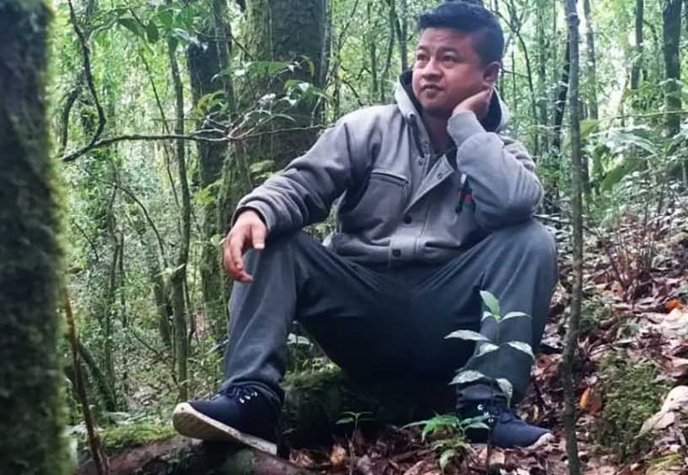 Borhlang Blah, 27, inside a sacred grove—a community forest protected by his village—in Mawphlang, Meghalaya. When Blah was growing up, the grove was denser and walking difficult. The grove and Meghalaya’s forests have thinned out since. Image by Disha Shetty. India, 2019. Borhlang Blah, 27, inside a sacred grove—a community forest protected by his village—in Mawphlang, Meghalaya. When Blah was growing up, the grove was denser and walking difficult. The grove and Meghalaya’s forests have thinned out since. Image by Disha Shetty. India, 2019.