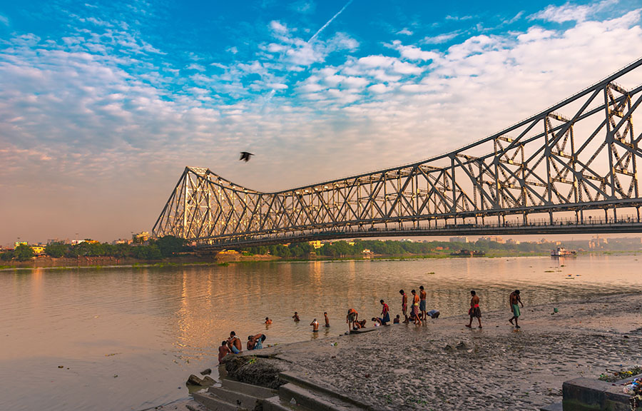 People bathe in the Ganges overlooking the Howrah Bridge in West Bengal. Image by ABIR ROY BARMAN / Shutterstock. India, 2019. People bathe in the Ganges overlooking the Howrah Bridge in West Bengal. Image by ABIR ROY BARMAN / Shutterstock. India, 2019.