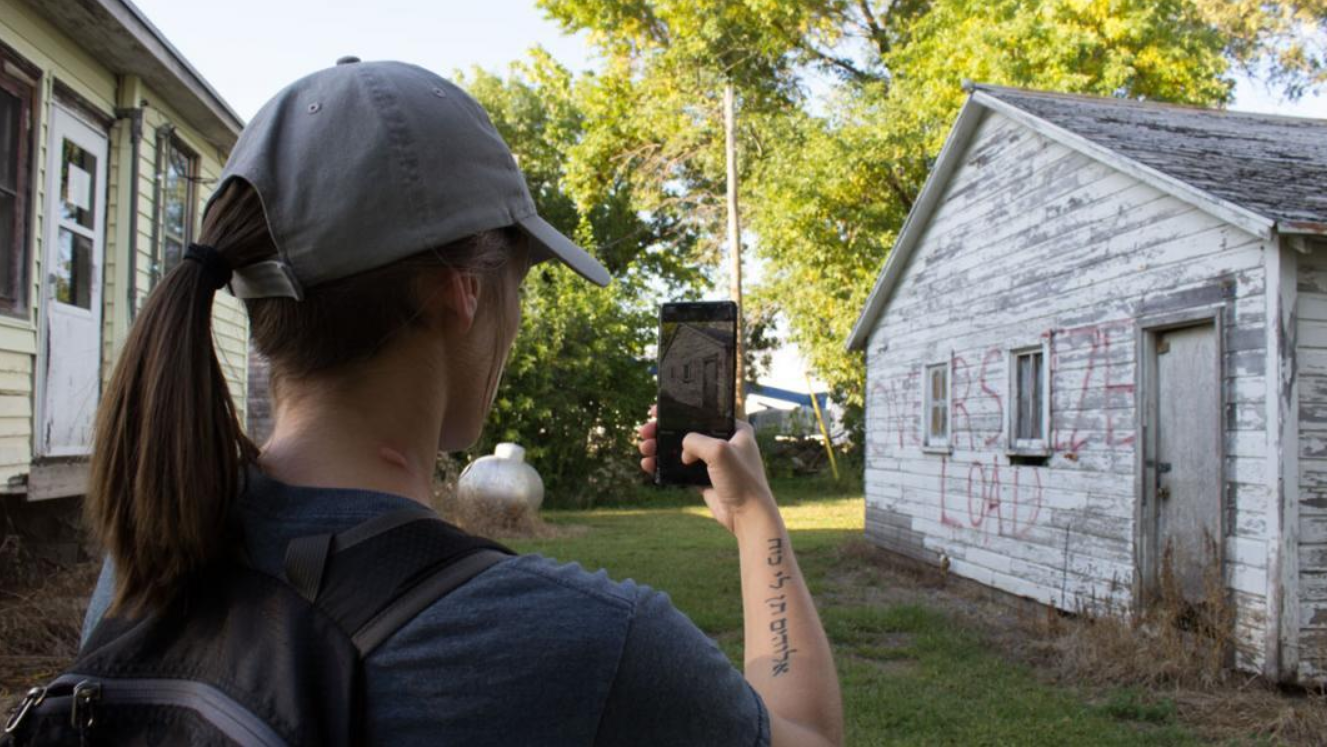 Kayla Vondracek photographs a structure preparing to be relocated. Image by University of Nebraska Lincoln. United States, 2020. Kayla Vondracek photographs a structure preparing to be relocated. Image by University of Nebraska Lincoln. United States, 2020.