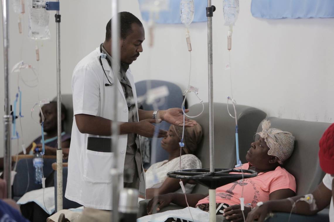 A physician talks to Paula Paul as she gets hydration before chemotherapy at the University Hospital of Mirebalais in central Haiti. Image by José A. Iglesias. Haiti, 2018. A physician talks to Paula Paul as she gets hydration before chemotherapy at the University Hospital of Mirebalais in central Haiti. Image by José A. Iglesias. Haiti, 2018.