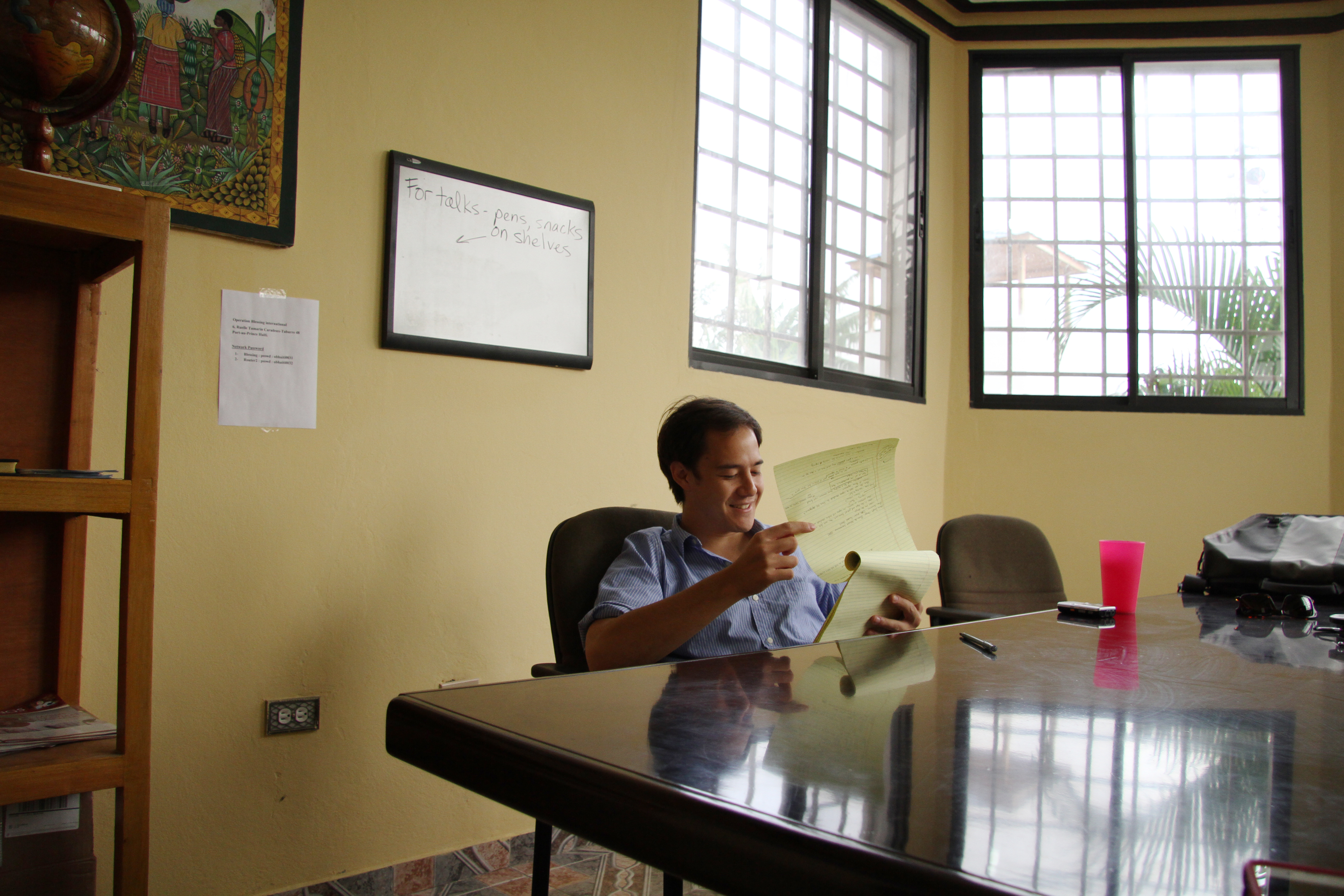 Jason Hayes reviews notes from interviews with lawyer Brian Concannon and Partners In Health program coordinator Cate Oswald after his first week in Haiti. Image by Meghan Dhaliwal. Haiti, 2013.